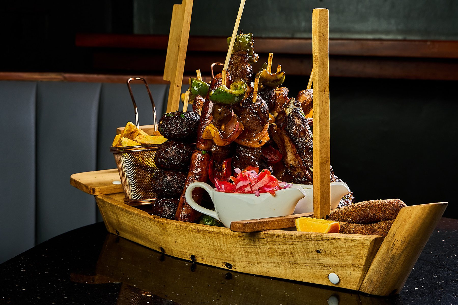 Villa platter boat loaded with skewers, ribs and fries